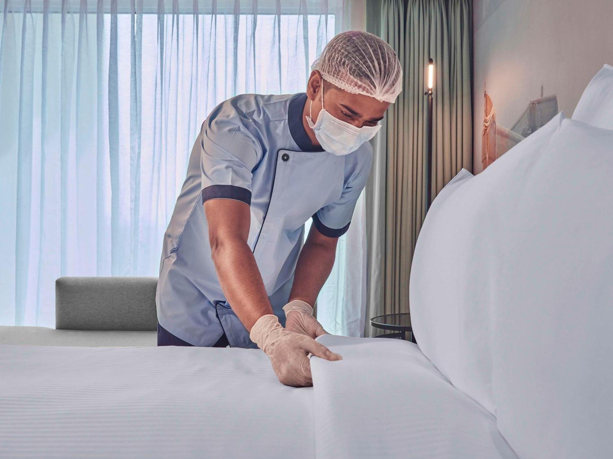Novotel Mumbai International Airport Bagian luar foto A hotel housekeeper making a bed