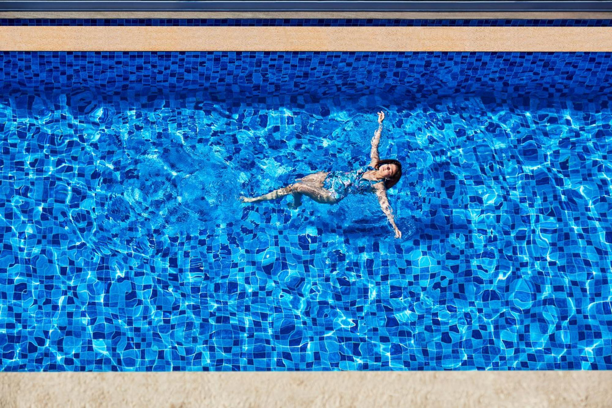 Novotel Mumbai International Airport Bagian luar foto A woman floating in a swimming pool