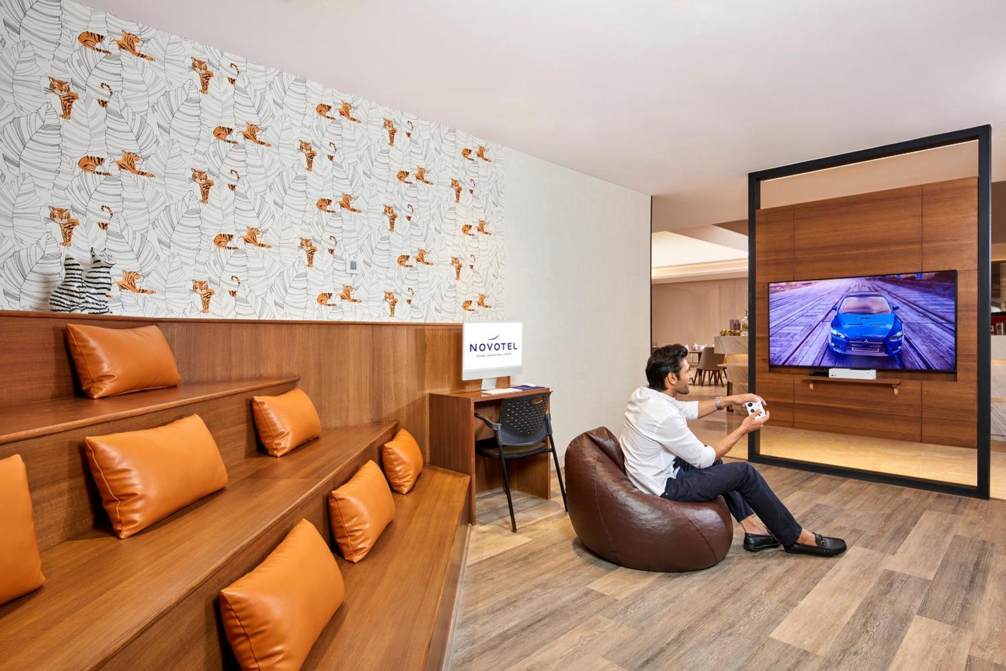 Novotel Mumbai International Airport Bagian luar foto A man playing a video game at the lounge