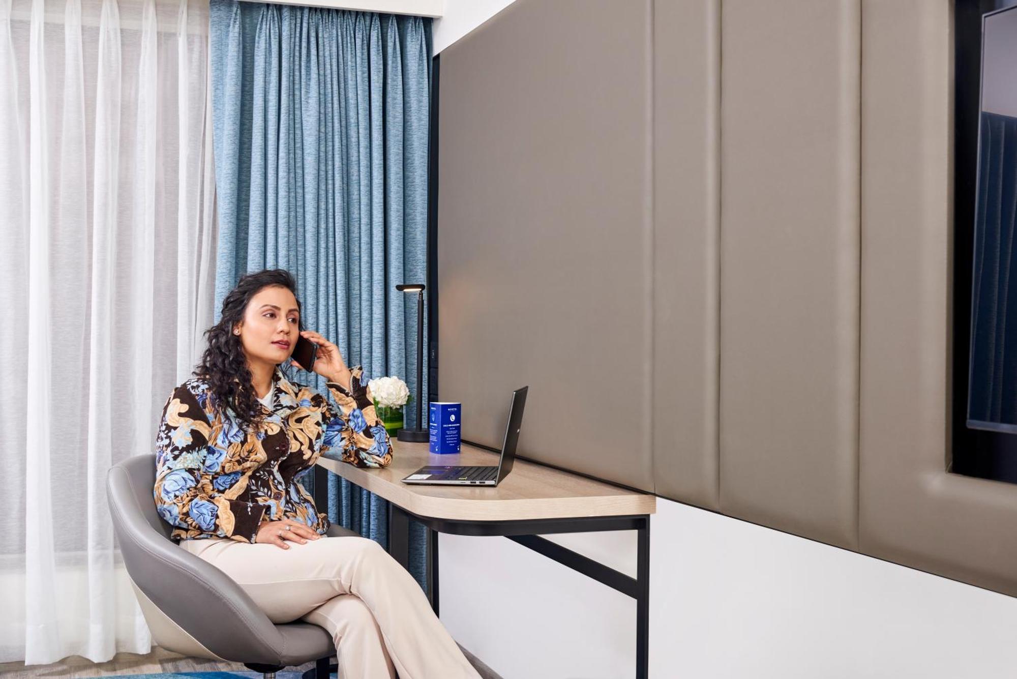 Novotel Mumbai International Airport Bagian luar foto A woman working from home